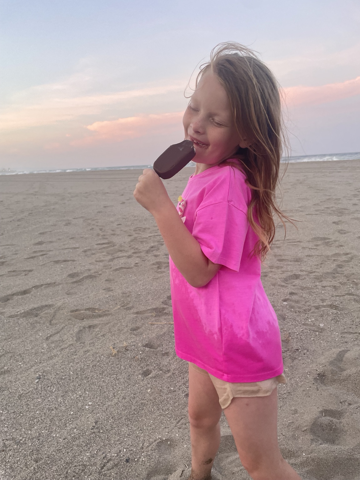 Dziewczynka w różowej koszulce na plaży